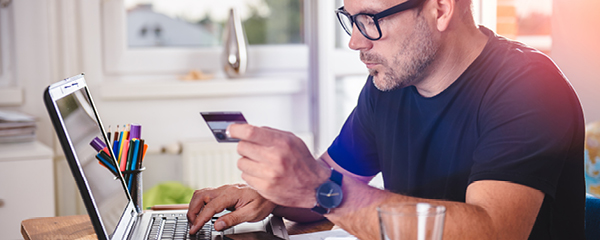 Man on computer typing in credit card information