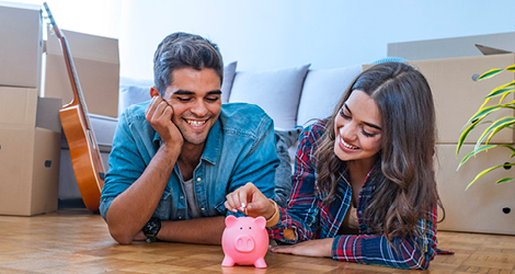 Man and woman in front of piggy bank