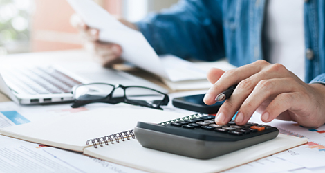 Person using calculator figuring out taxes