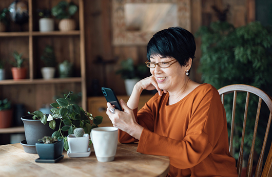 Woman sitting at table looking at phone